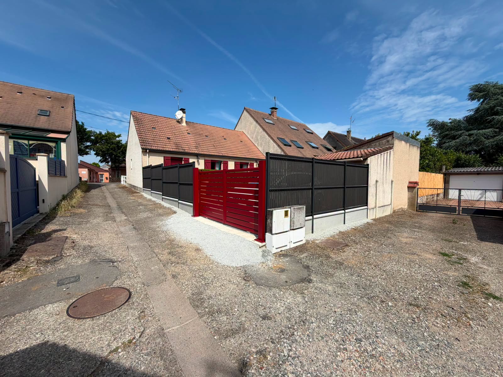 Un portail rouge, une clôture coordonnée